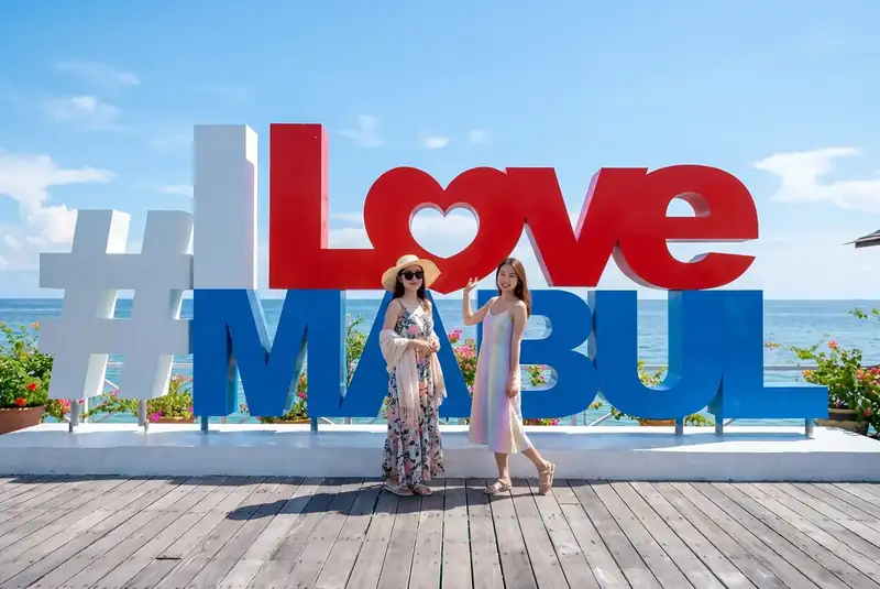 Taking photos at the I Love Mabul sign on Mabul Island Arcadia Beach Resort